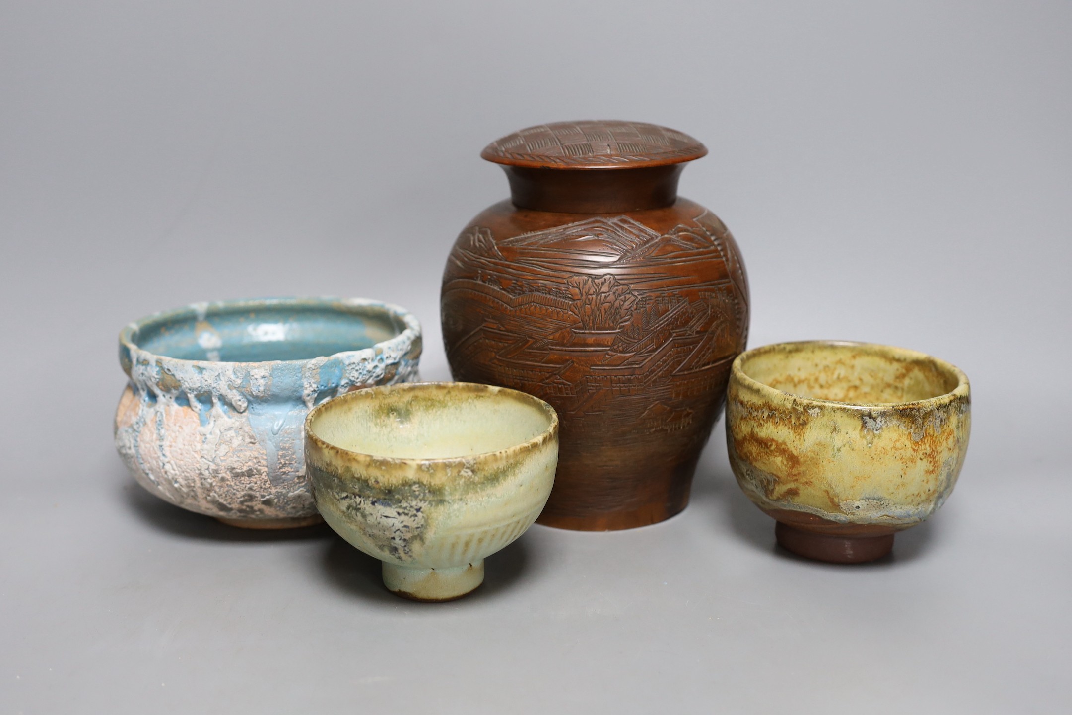 Two Japanese stoneware tea bowls (chawan), a Japanese raku bowl and a Japanese carved wood tea caddy, 19cm